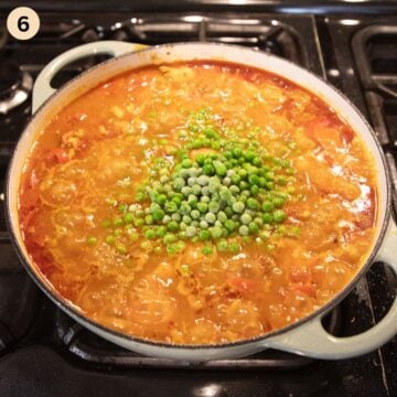adding frozen peas to paella with chicken and chorizo.