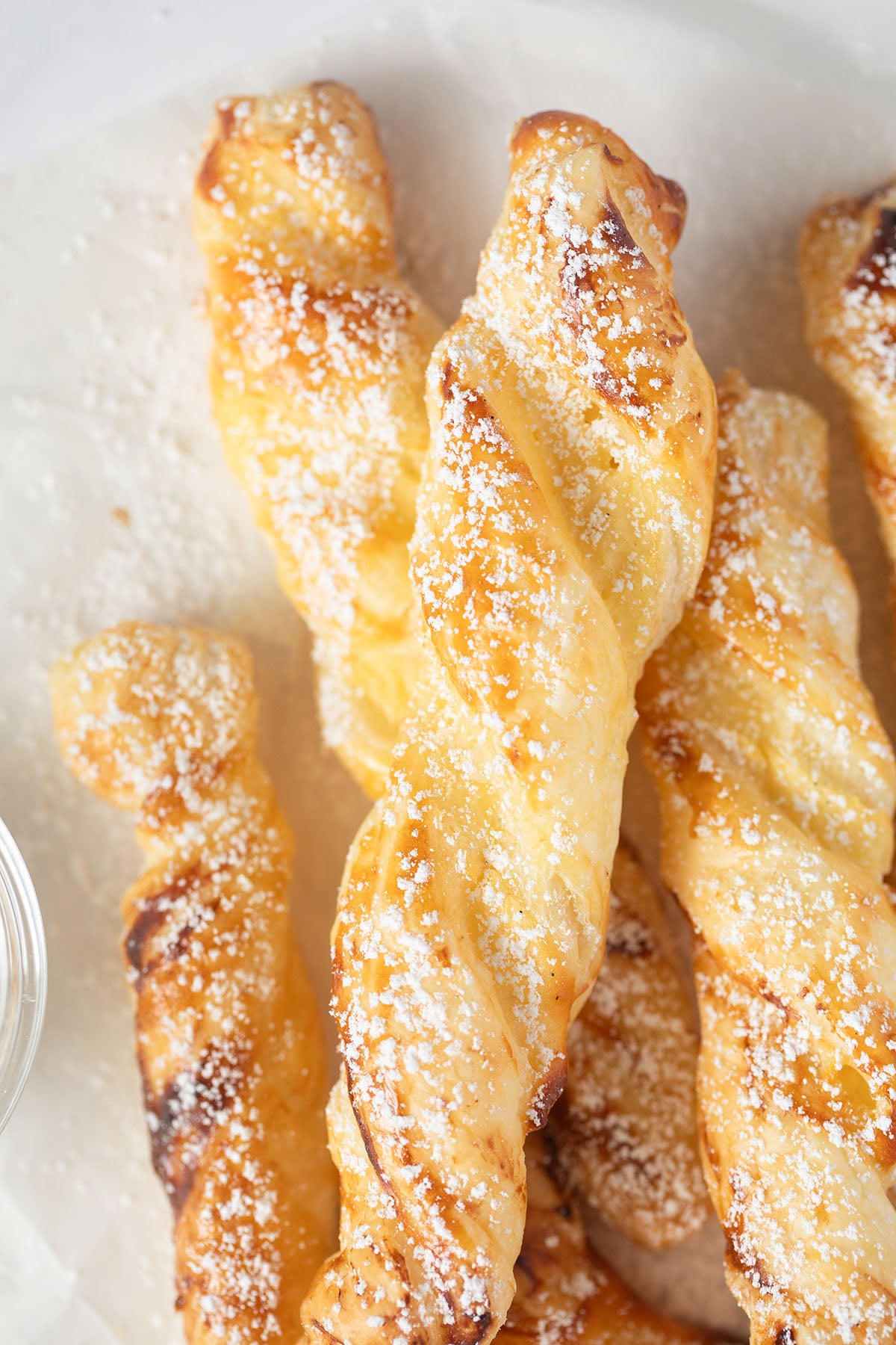 golden baked cream cheese puff pastry twists dusted with powdered sugar.