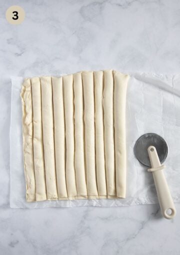 cutting puff pastry and cream cheese pieces with a pizza cutter.