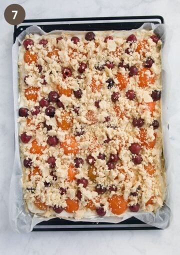 fruit crumble cake on a baking sheet before baking.