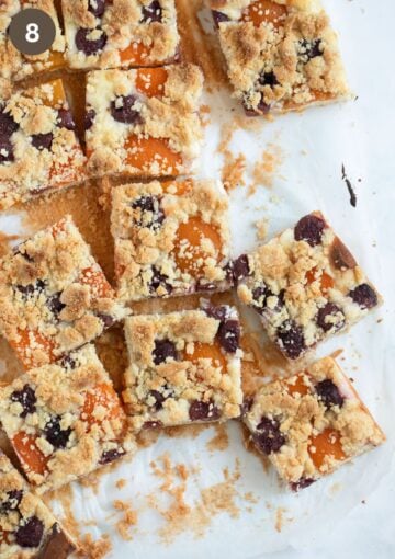 cooled and cut fruit crumble cake on parchment paper.