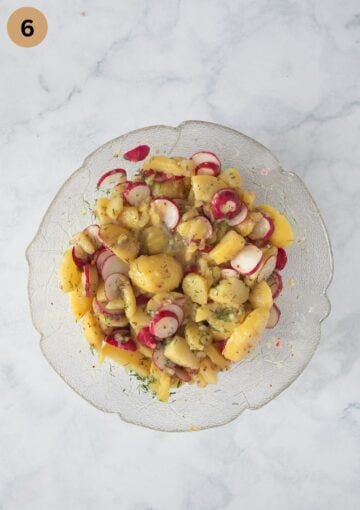 tossed salad with potatoes, radishes and dill in a bowl.
