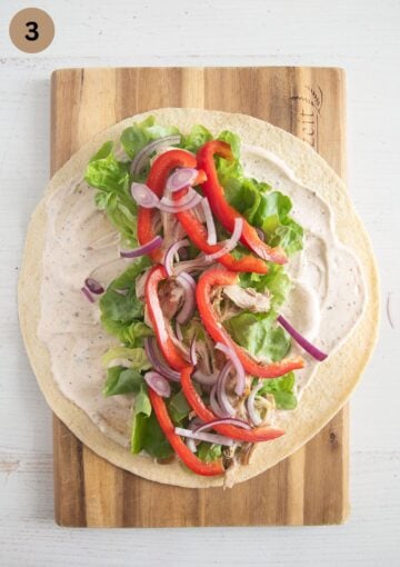adding sliced peppers and onions to wraps.