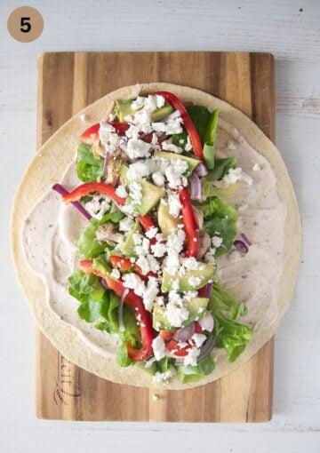 adding feta to chicken tortilla wraps.