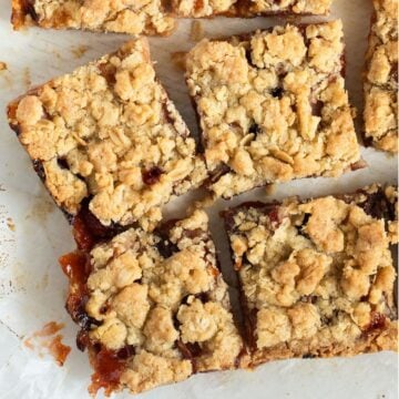 peach crumble bars cut into pieces on parchment paper.