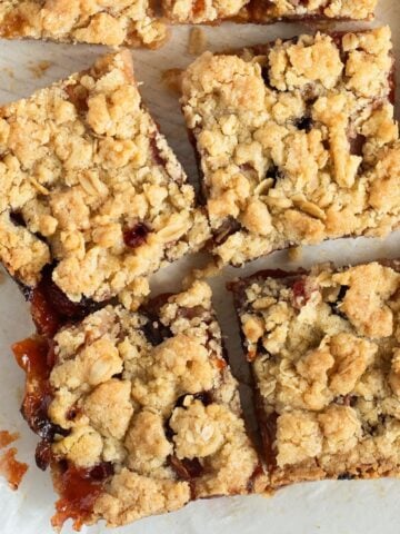 peach crumble bars cut into pieces on parchment paper.