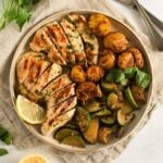 quick marinated chicken breast served with potatoes and zucchini on a plate.