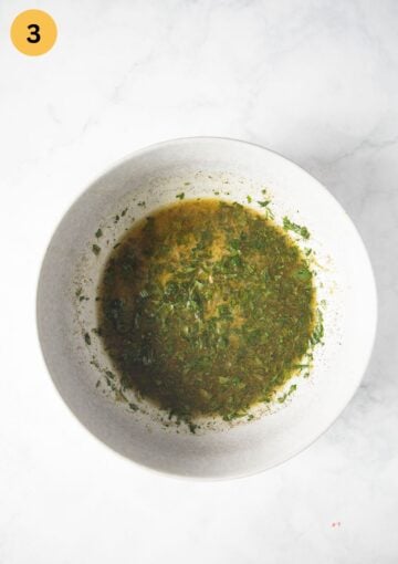 lemon, garlic, and parsley marinade for chicken breast in a bowl.