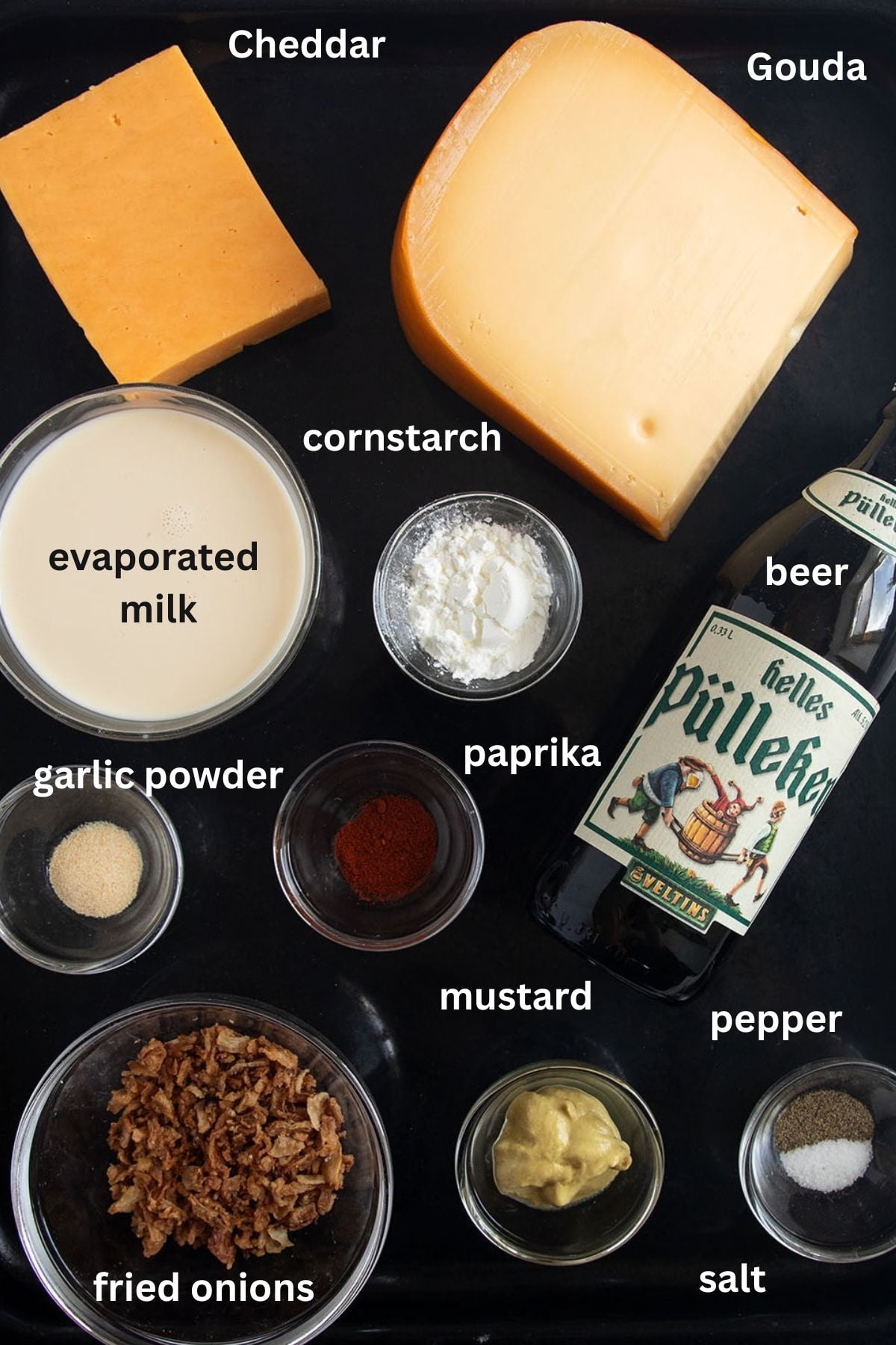 labeled ingredients for making pretzel dip with cheese, beer, evaporated milk, and crispy onions.