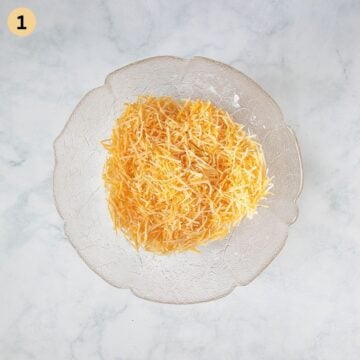 grated cheese mixed with cornstarch for making pretzel cheese dip in a bowl.