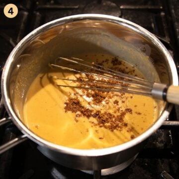 stirring crispy fried onions in beer cheese pretzel dip.