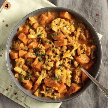 serving curry with cauliflower and sweet potatoes in a bowl.