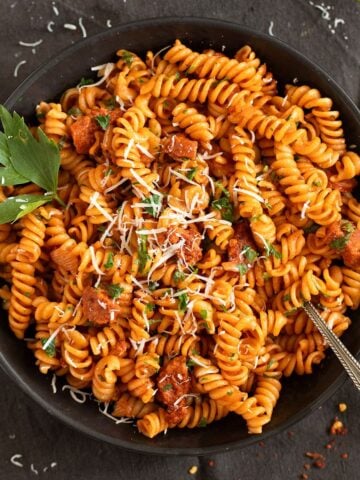 chorizo pasta sprinkled with parmesan and garnished with parsley.