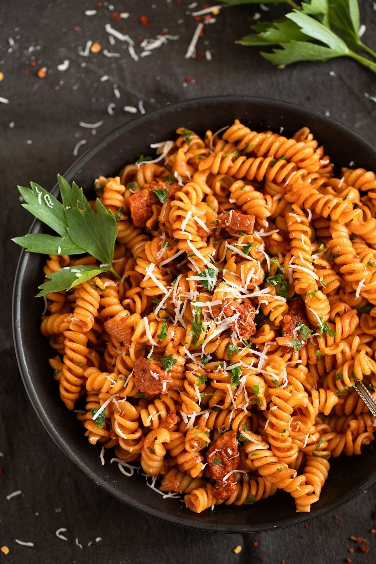 chorizo pasta with tomato sauce and parmesan in a bowl.