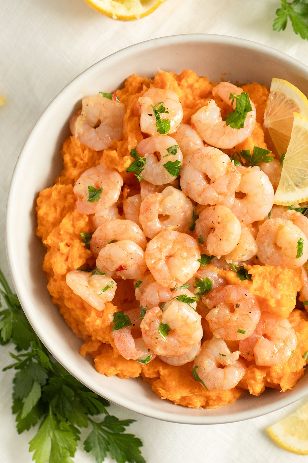 small shrimp with butter served on creamy mashed sweet potatoes.