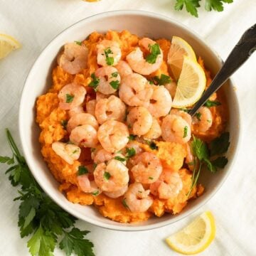 shrimp and sweet potato mash served with lemon wedges in a bowl.