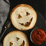 two halloween quesadillas with smilling jack'o'lantern faces and salsa.