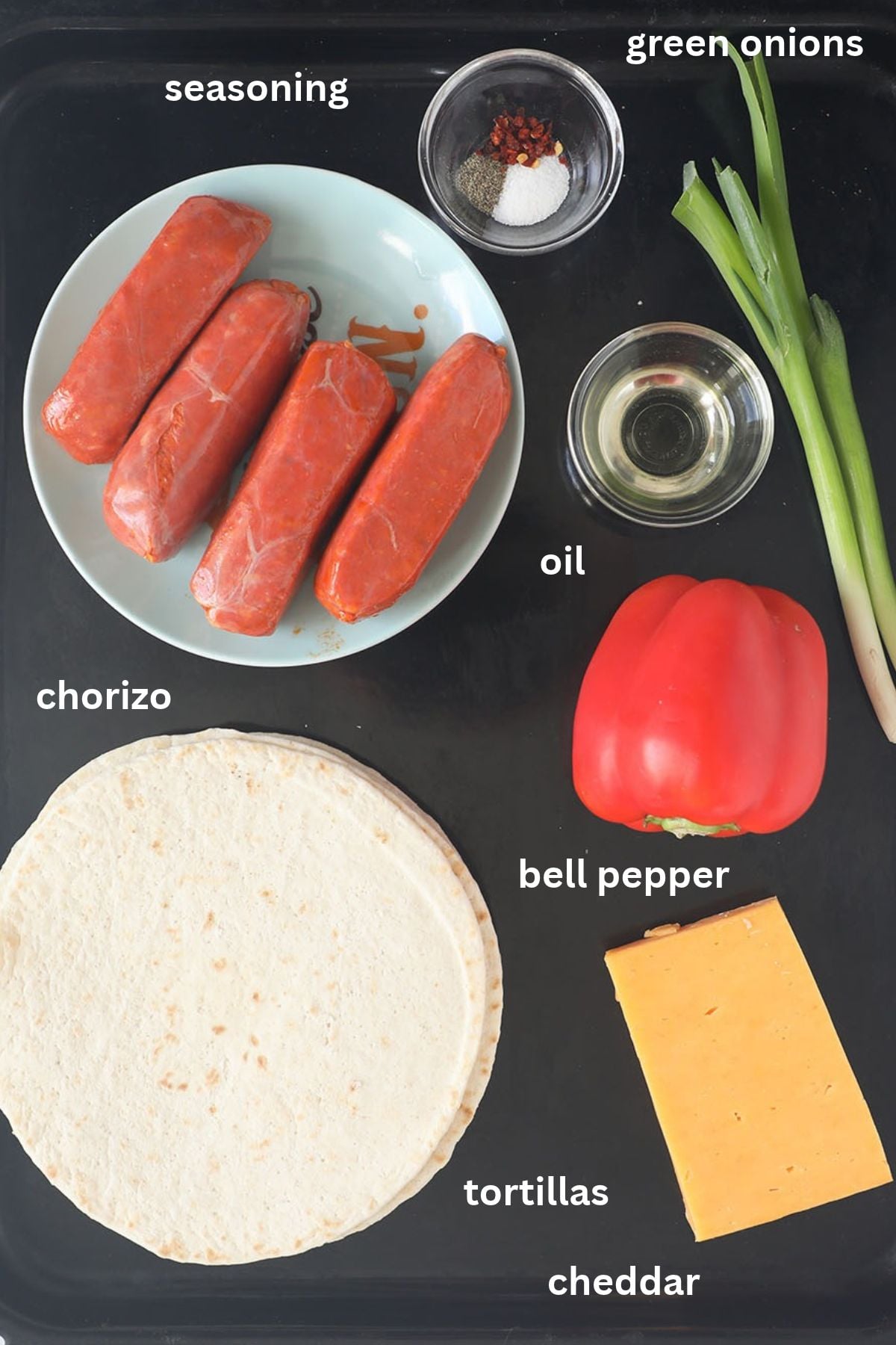 labeled ingredients for making halloween quesadillas with tortillas, chorizo, cheddar, pepper, and green onions.