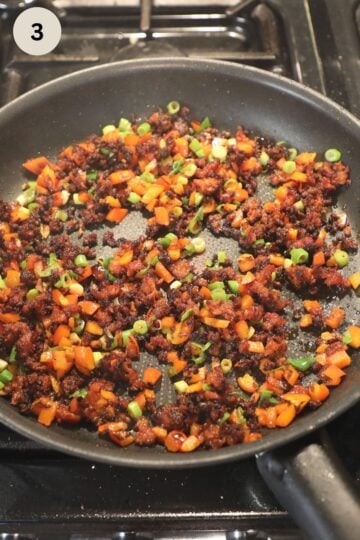 cooking chorizo, peppers, and green onions for making quesadilla filling.