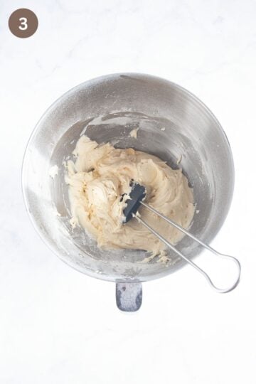 adding flour to cake bake with a rubber spatula.