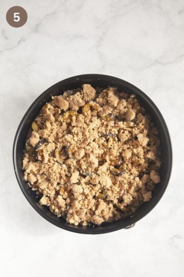 assemble cake with plums and crumbles in a bowl.