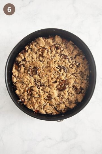 baked plum cake with crumbles in a springform.